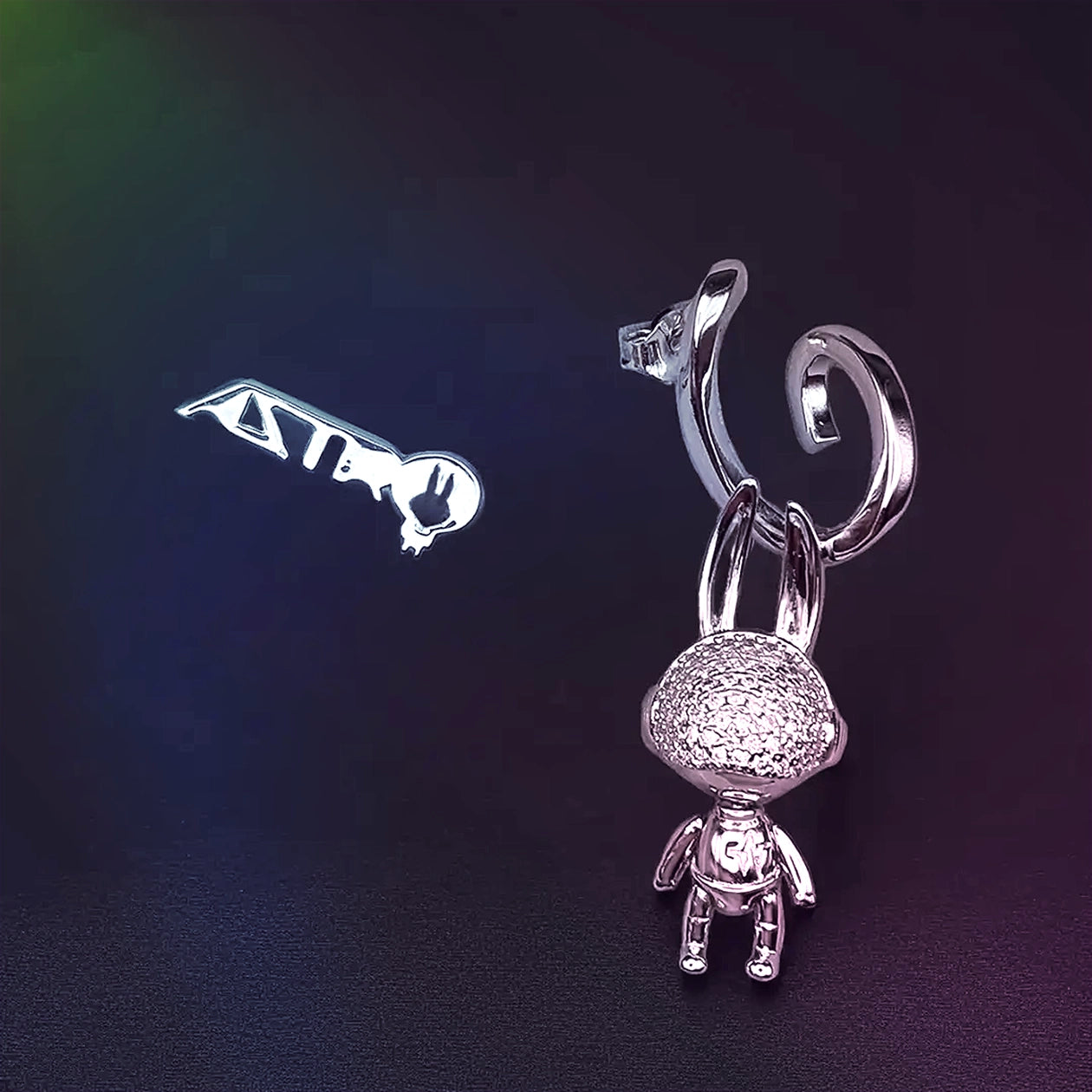 Silver key-shaped earring on a dark background