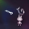 Silver key-shaped earring on a dark background